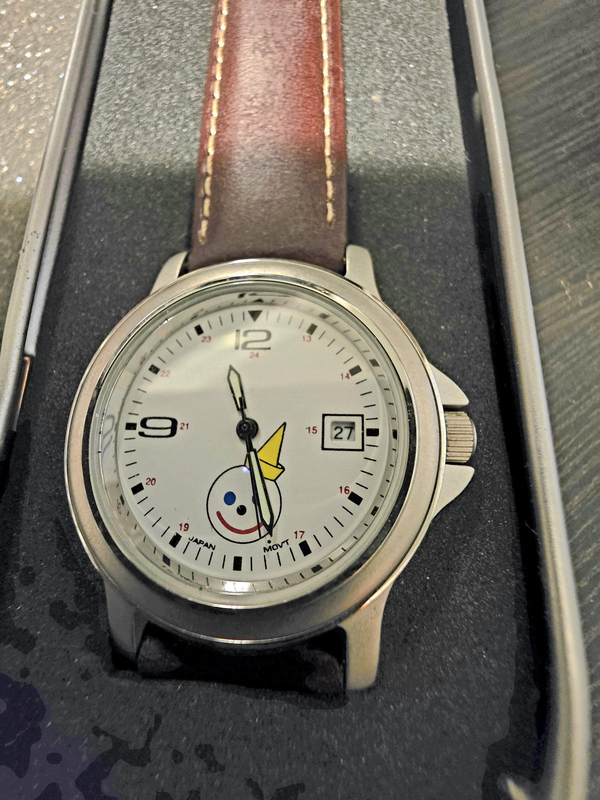 Close-up of Jack in the Box logo on vintage analog wristwatch with date window and white face