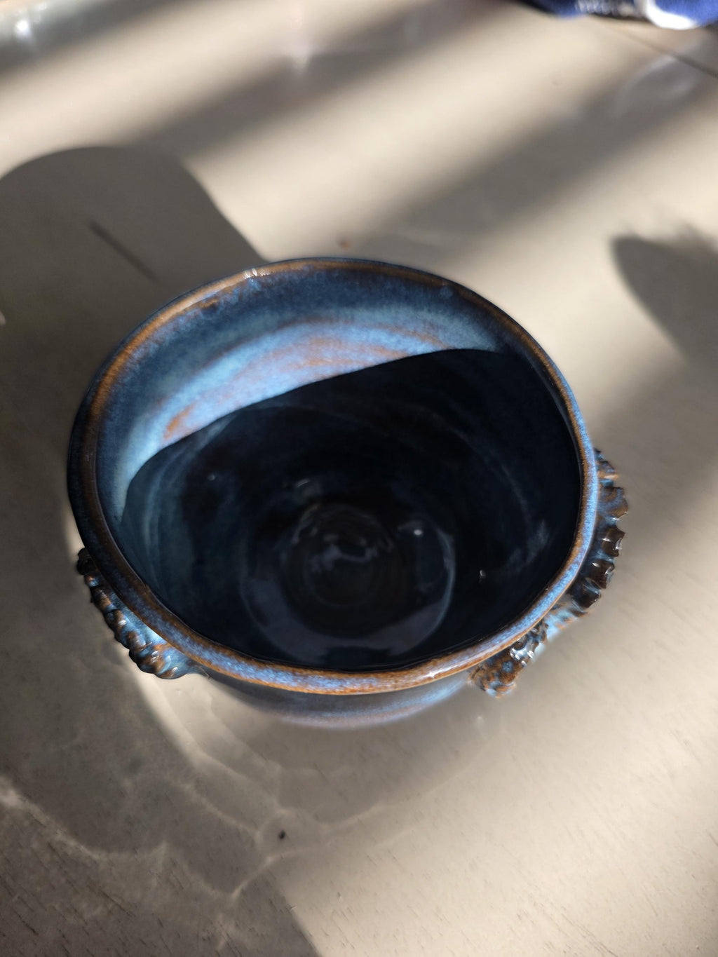 Octopus mug in black clay, handmade by Outer Reef Ceramics